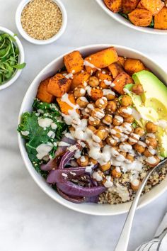 two bowls filled with different types of food on top of a white table next to plates and utensils