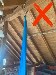 a blue hammock hanging from the ceiling in a room with wooden walls and beams