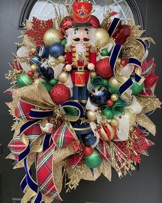 a christmas wreath with a nutcracker and decorations hanging from the front entrance door