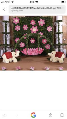 two stuffed animals sitting on top of a table next to pink flowers and greenery