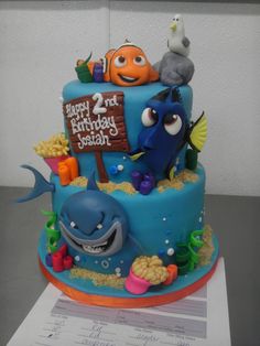 a blue birthday cake decorated with cartoon characters