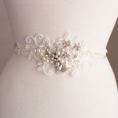 Ivory Bridal belt  Bridal sash Wedding dress belt sash Flower Pearl Bridal  belt Wedding Accessories Bridal accessories Bridal sash with pearls and crystals WEDDING SASH BELT DETAILS Bridal sash, perfect for vintage inspired or one very romantic wedding.  Color: light ivory /ivory/clear/silver Lace accent size: approx 9-9.5 inches, width approx 3 inches. Light ivory beaded lace. Materials: lace, ivory faux pearls, clear  crystals, seed beads. Satin ribbon in ivory 25mm x 260 cm, for you to tie a bow at the back. Lace headpieces and other sashes available in our shop please check. Simple packaging as in stock at this moment. Wedding  Belts: https://www.etsy.com/uk/shop/DonataleFlowers4You? section_id=14095241&ref=shopsection_leftnav_8 Lace Headpieces: https://www.etsy.com/uk/shop/DonataleAc White Bridal Belt For Bride, Elegant White Embroidered Belt, White Embroidered Belt For Party, Elegant Bridal Sashes For Bride, Elegant Bridal Sashes, Elegant White Bride Sashes, Elegant White Belt With Sashes, Lace Bridal Belt With Sashes For Wedding, Elegant Bridal Belt With Sashes For Bride