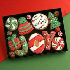 decorated christmas cookies in a black box on a red and green background