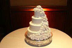 a three tiered white wedding cake on a table