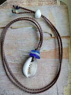 Handmade Blue Sea Glass Necklace Men Women Sinew Braid Hawaiian Cowrie Shell Unique Beach Jewelry With Adjustable Cord, Artisan Blue Jewelry For Beach, Artisan Blue Jewelry For The Beach, Beach Jewelry Blue Hand-wrapped, Artisan Jewelry With Adjustable Cord For Beach, Handmade Blue Strand Jewelry, Blue Adjustable Cord Necklace For Beach, Bohemian Blue Jewelry With Adjustable Cord, Blue Jewelry With Adjustable Cord For Vacation