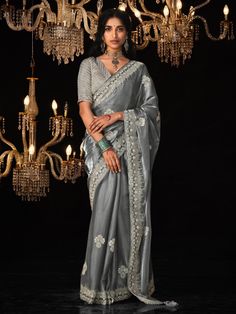 Our grey tissue silk saree is a true masterpiece of timeless beauty and contemporary allure. This exquisite saree is adorned with intricate sequin work, shimmering stonework, detailed embroidery, and luxurious zarkan work, each element meticulously crafted to perfection.
The saree comes with a matching silk material blouse, also embellished with sequins, stonework, embroidery work, and zarkan work.
Made from high-quality tissue silk, this saree measures 5.50 meters and comes with unstitched blouse material for customization. Drapping Saree, Saree Beautiful, Tissue Silk Saree, Embroidery Border, Party Wear Saree, Party Kleidung, Gray Silk, Wear Saree, Organza Saree