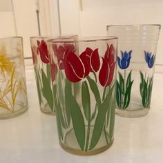 four glass cups with flowers painted on them