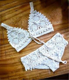 two pieces of crocheted lace sitting on top of a wooden table