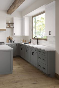 a kitchen with gray cabinets and white counter tops