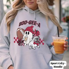 Gear up, Georgia fans! Our Boo-Gee-A Georgia Football Hoodie is the ultimate must-have for Saturdays in Athens, celebrating your love for the Dawgs in style. Whether it's football season or fall festivities, this cozy sweatshirt is your new go-to. Don't miss out on this unique piece of spirit wear. Add a dash of fun to your wardrobe and show off that Georgia pride! Grab yours now--there's no time to waste when it comes to flaunting your love for the Bulldogs. Go Dawgs! Hoodie Details: This unisex heavy blend hooded sweatshirt is relaxation itself. Made with a thick blend of cotton and polyester, it feels plush, soft and warm, a perfect choice for any cold day. In the front, the spacious kangaroo pocket adds daily practicality while the hood's drawstring is the same color as the base sweate Ga Football, No Time To Waste, Hoodie Details, Go Dawgs, Georgia Football, Fall Festivities, Spirit Wear, Fall Festival, Cozy Sweatshirts