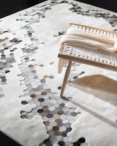 a white rug with hexagonal shapes on it and a chair in the middle