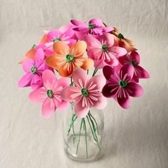 a vase filled with pink and orange paper flowers