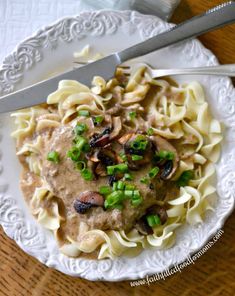 a white plate topped with pasta covered in mushroom sauce