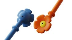 an orange and blue toothbrush with a flower on the top one has a yellow eye