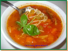 a bowl of soup with noodles, carrots and spinach on the side is shown