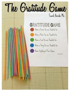 a group of colored straws sitting next to a paper with the words, the gratitude game