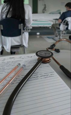 a medical notepad with a stethoscope on it and people in the background