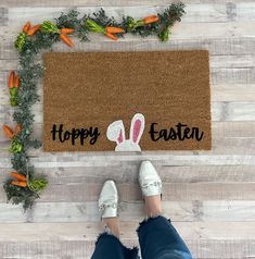 a person standing in front of a door mat that says happy easter