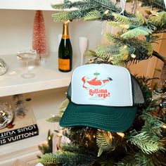 a christmas tree with a hat hanging from it's side and bottles in the background