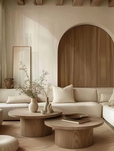 a living room filled with white furniture and wooden accents on the walls, along with a round coffee table