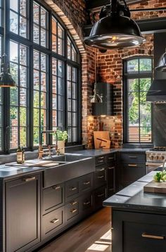 a kitchen with black cabinets and large windows