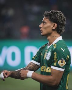 a soccer player with his arm wrapped around the wrist and looking off into the distance