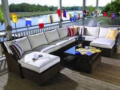 an outdoor living area with couches, tables and flags on the side of the porch