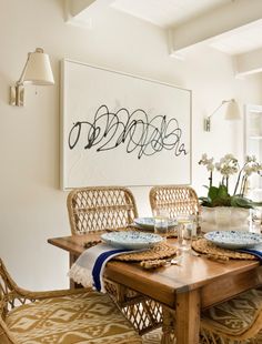 the dining room table is set with place mats and place settings for two people to eat