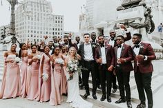 a group of people standing next to each other in front of a building with tall buildings