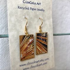 a pair of earrings is displayed on a piece of paper that says lincoln art recycled paper jewelry