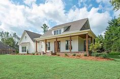 a large white house sitting on top of a lush green field