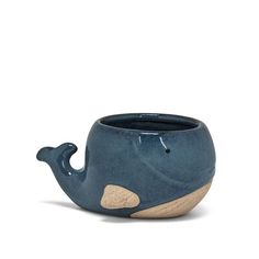 a blue ceramic whale planter sitting on top of a table