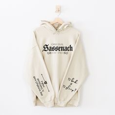 a white hoodie with writing on the front and back, hanging from a hanger