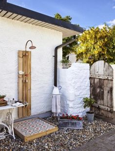 the outside of a white house with an outdoor shower