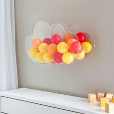 there are balloons in the shape of clouds hanging on the wall next to cubes