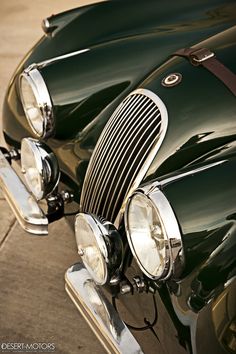 the front end of an old fashioned green car