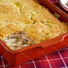 a casserole dish filled with meat and vegetables on a red checkered table cloth