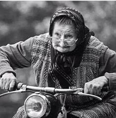 an old woman riding on the back of a motorcycle