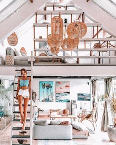 a woman standing on top of a bed in a loft