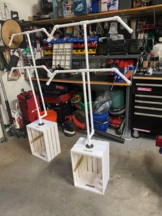 two white crates sitting next to each other in a room filled with tools and supplies