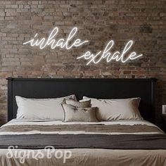 a bedroom with brick walls and a large bed in the middle that says, whale exhale