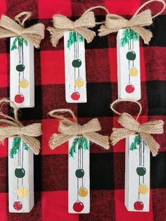 four wooden tags tied together with twine and burlocks on a red checkered table cloth