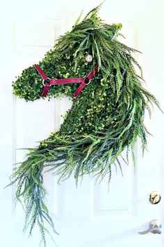 a horse made out of plants hanging on a door