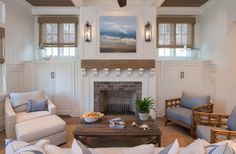 a living room with couches, chairs and a fire place in the center area