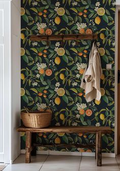 a wallpapered room with a bench, coat rack and oranges on it