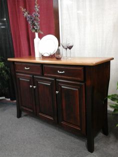 a wooden buffet table with wine glasses on top