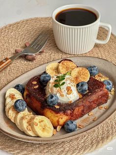 a plate topped with bananas and blueberries next to a cup of coffee