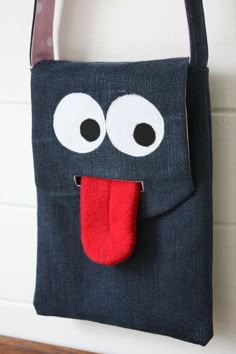 a black bag with a red tongue sticking out of it's mouth and eyes