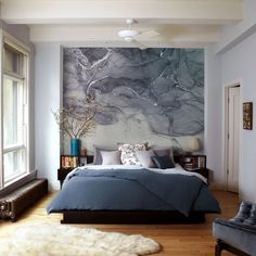 a bedroom with a large marble wall behind the bed and rugs on the floor