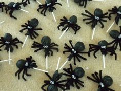 there are many black spider lollipops on the table